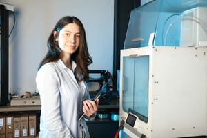 Engineer analyzing smart manufacturing data beside automated equipment, representing alignment between people, process, and technology.